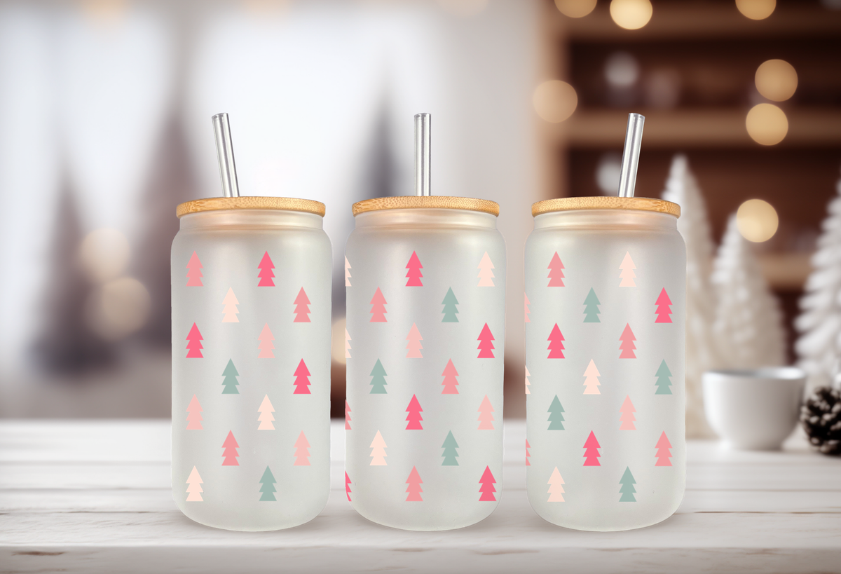 MOCKUP OF Three 16oz glass can tumblers with bamboo lids displaying pastel Christmas tree UVDTF wrap designs