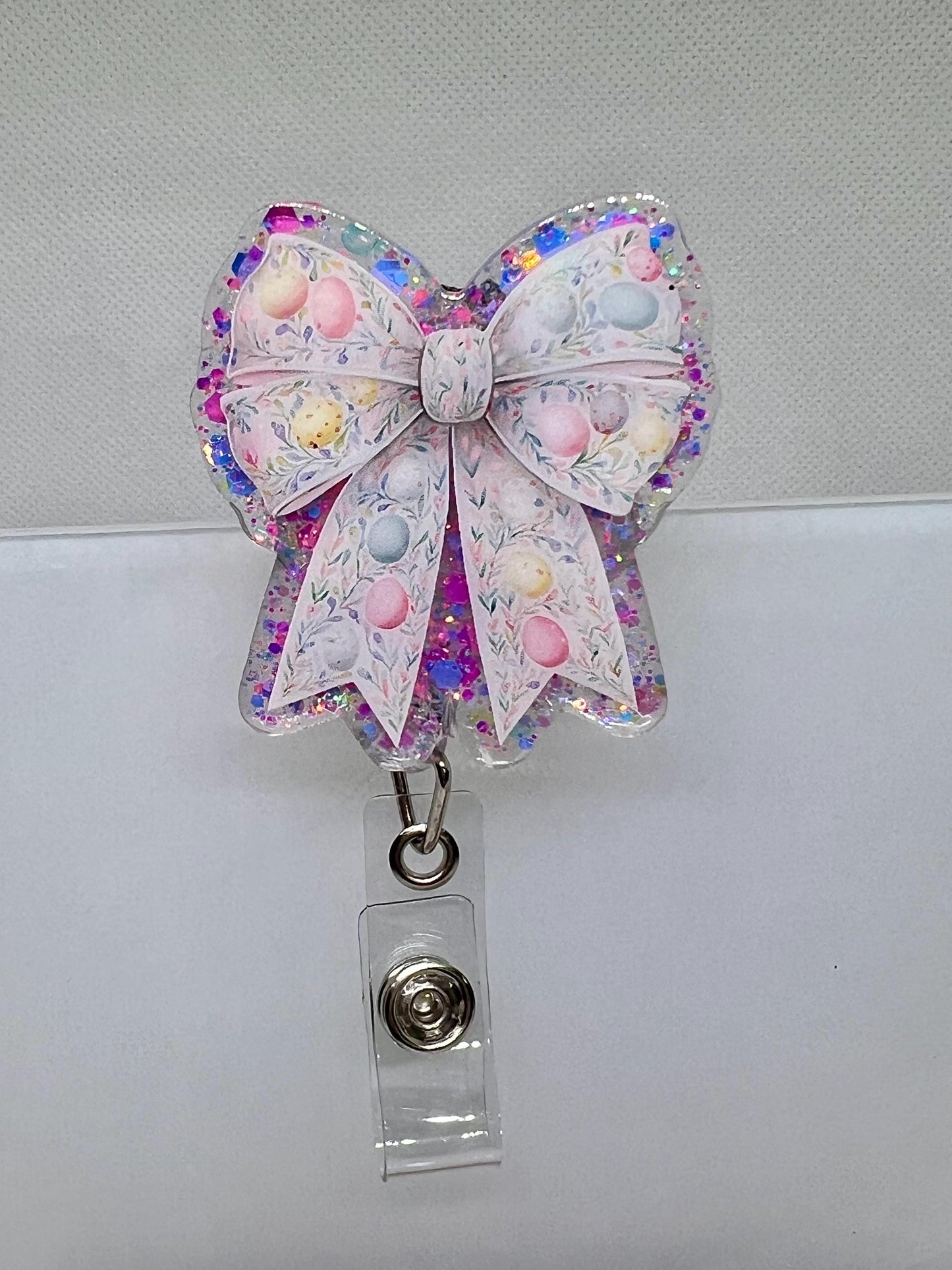 Glittery Easter Bow Badge Reel – Pastel Egg and Floral Design for Nurses, Teachers, and Professionals