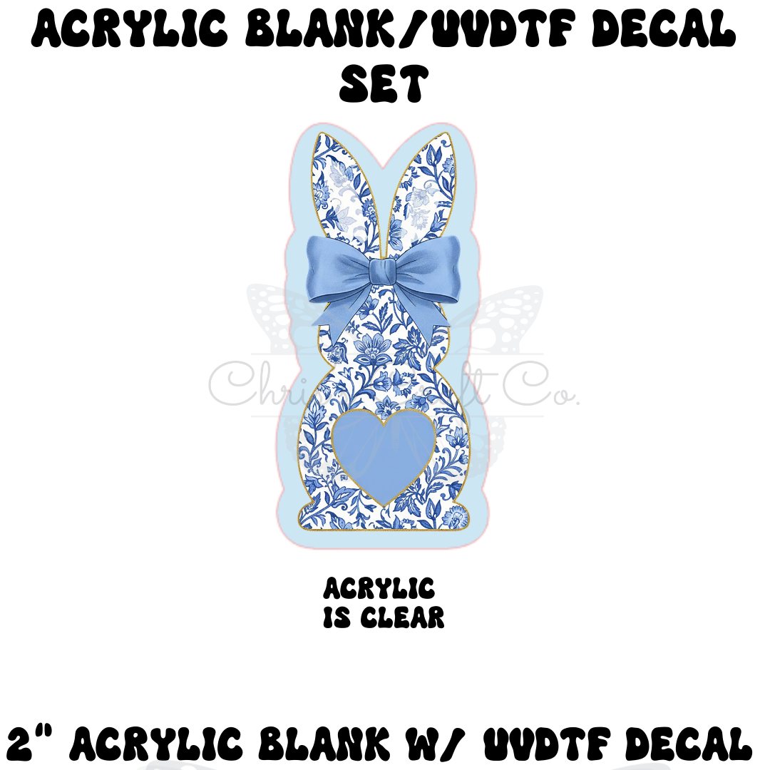 A DIY badge reel kit featuring a clear bunny-shaped acrylic blank and a UV DTF decal with a blue and white floral chinoiserie pattern, a blue bow, and a blue heart.