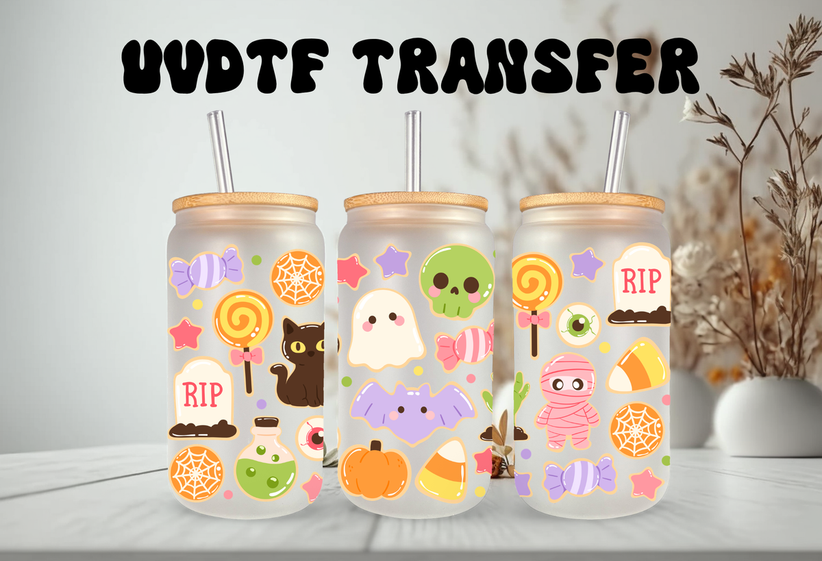 MOCKUP OF Clear frosted glass 16oz can tumblers with bamboo lids and glass straws, decorated with a pastel Halloween sugar cookies UVDTF wrap featuring ghost cookies, mummy cookies, candy corn, and skull lollipops.