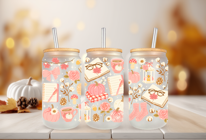 Cozy pink bookish autumn UV DTF wrap featuring reading glasses, open books, pink pumpkins, coffee mugs, and autumn foliage for 16oz glass can tumblers.