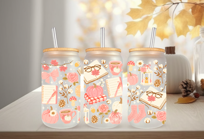 Cozy pink bookish autumn UV DTF wrap featuring reading glasses, open books, pink pumpkins, coffee mugs, and autumn foliage for 16oz glass can tumblers.