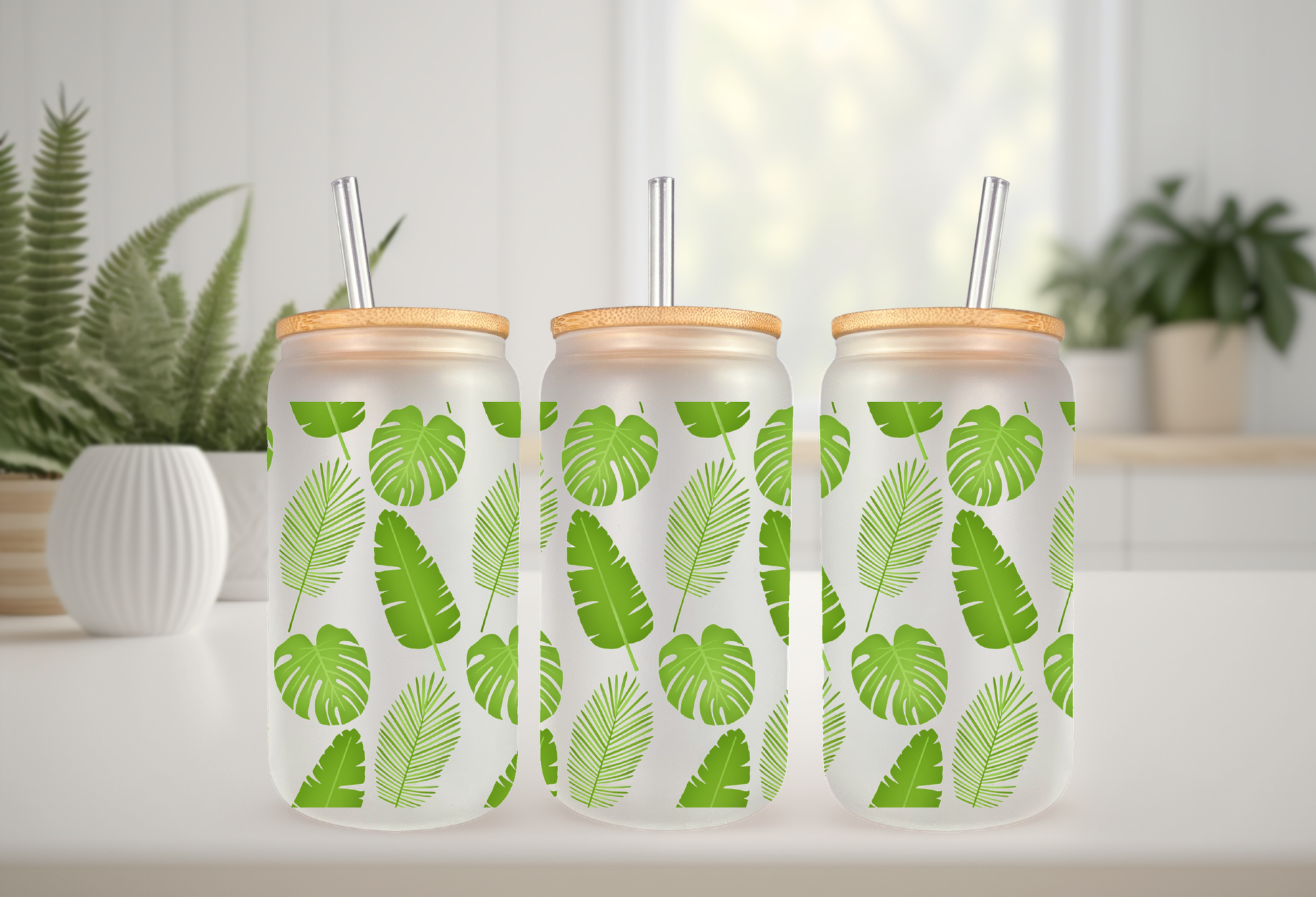 mockup of a 16oz frosted can glass wrap featuring a vibrant green botanical design with detailed monstera leaves and tropical palm fronds on a clear background.