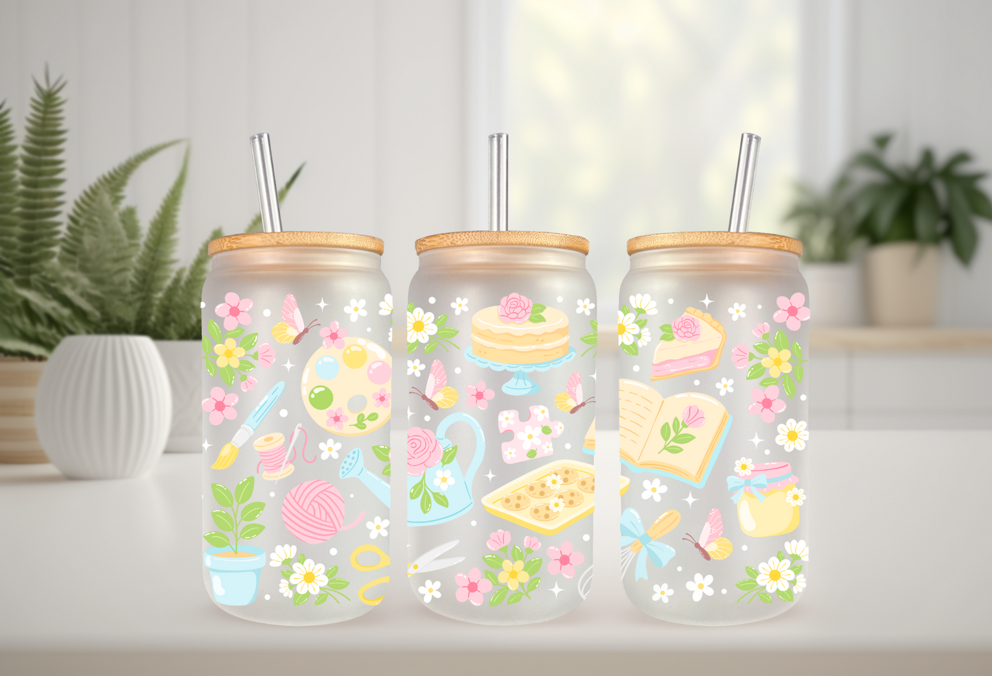 Mockup of three frosted glass cans with floral and hobby-themed UVDTF transfers, including bookish and crafty designs.