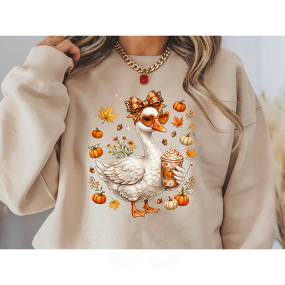 Ready to press DTF apparel transfer on a white t-shirt mockup featuring a white fall porch goose holding a pumpkin spice latte with autumn leaves