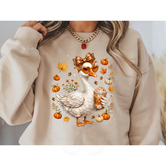 Ready to press DTF apparel transfer on a white t-shirt mockup featuring a white fall porch goose holding a pumpkin spice latte with autumn leaves