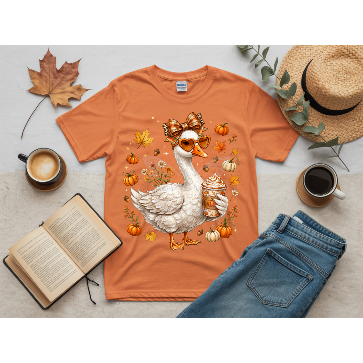 Ready to press DTF apparel transfer on a white t-shirt mockup featuring a white fall porch goose holding a pumpkin spice latte with autumn leaves