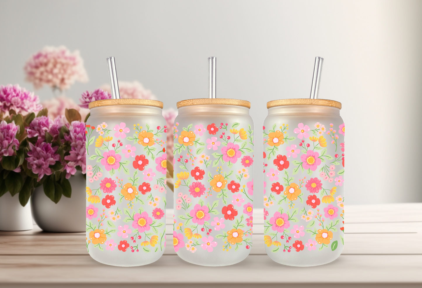 MOCKUP OF A 16oz frosted can glass wrap featuring a retro groovy floral design with bright pink, red, and yellow daisies on a clear background.