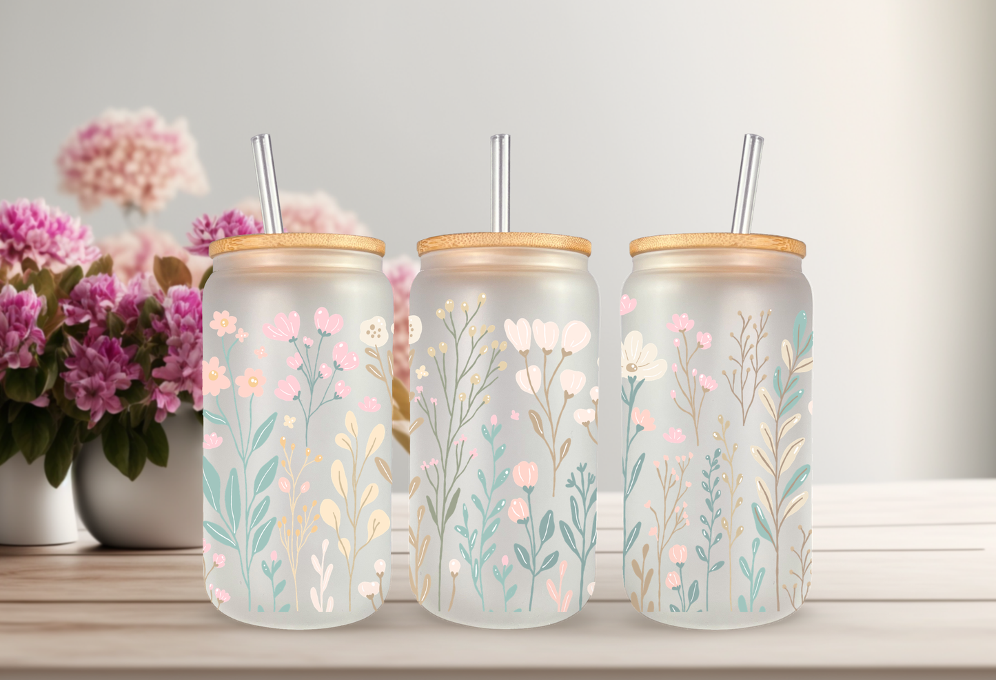 Mockup of 16oz can glass wrap featuring delicate pastel wildflowers, pink daisies, blue blossoms, and green leaves on a clear background.