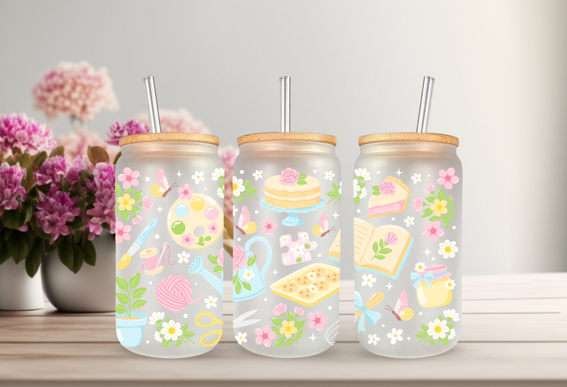 Mockup of three frosted glass cans with floral and hobby-themed UVDTF transfers, including bookish and crafty designs.