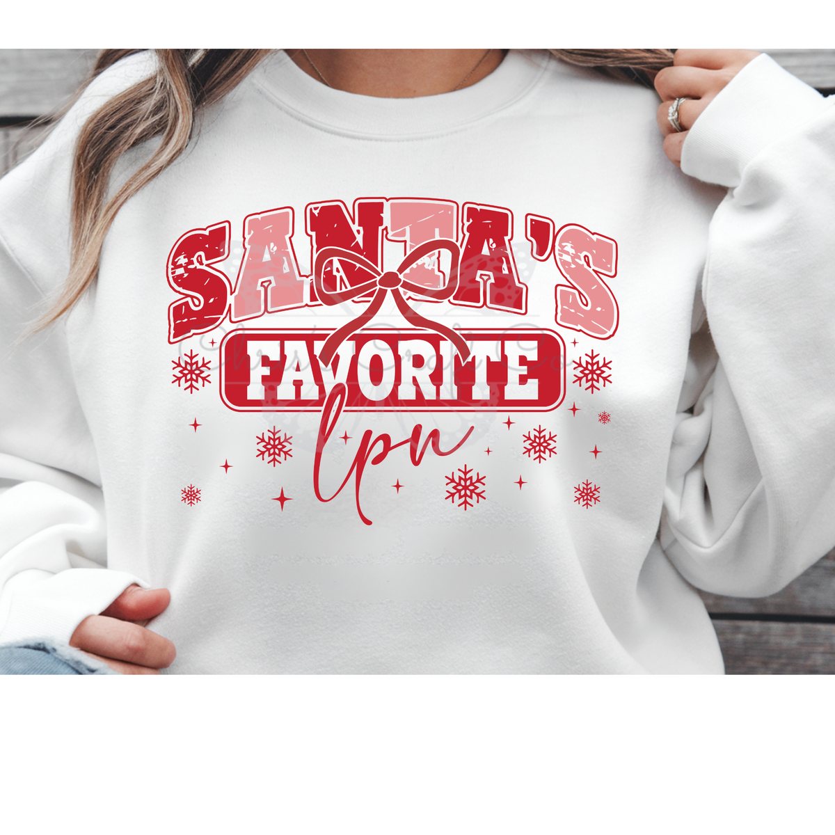 Grey t-shirt mockup featuring a Santa's Favorite LPN DTF transfer with red and pink glitter text and snowflakes.