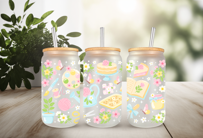 Mockup of three frosted glass cans with floral and hobby-themed UVDTF transfers, including bookish and crafty designs.