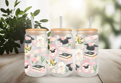16oz can glass wrap featuring teddy bears in graduation caps, diplomas, stacks of books, pink coquette bows, and spring flowers on a clear background.