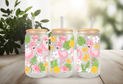 16oz can glass wrap featuring pink flamingos with polka dot bows, tropical pineapples, pink hibiscus, and green palm leaves on a clear background.