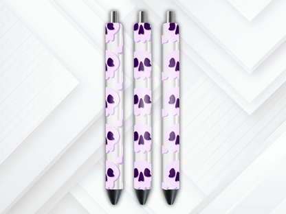 Pen wrap mockup featuring three white gel pens decorated with pastel purple skulls and bones UV DTF transfers.