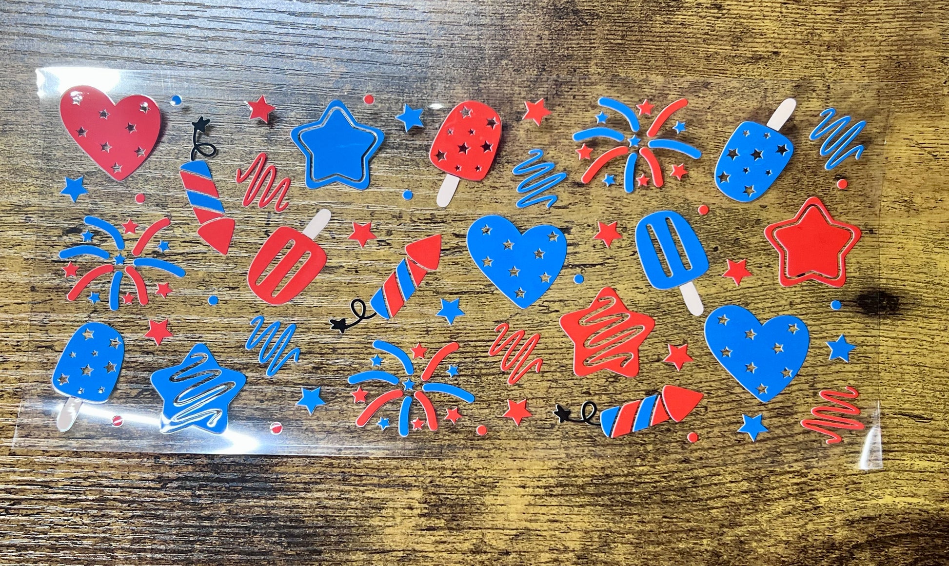 Colorful firework-themed stickers in a clear plastic bag on a wooden surface