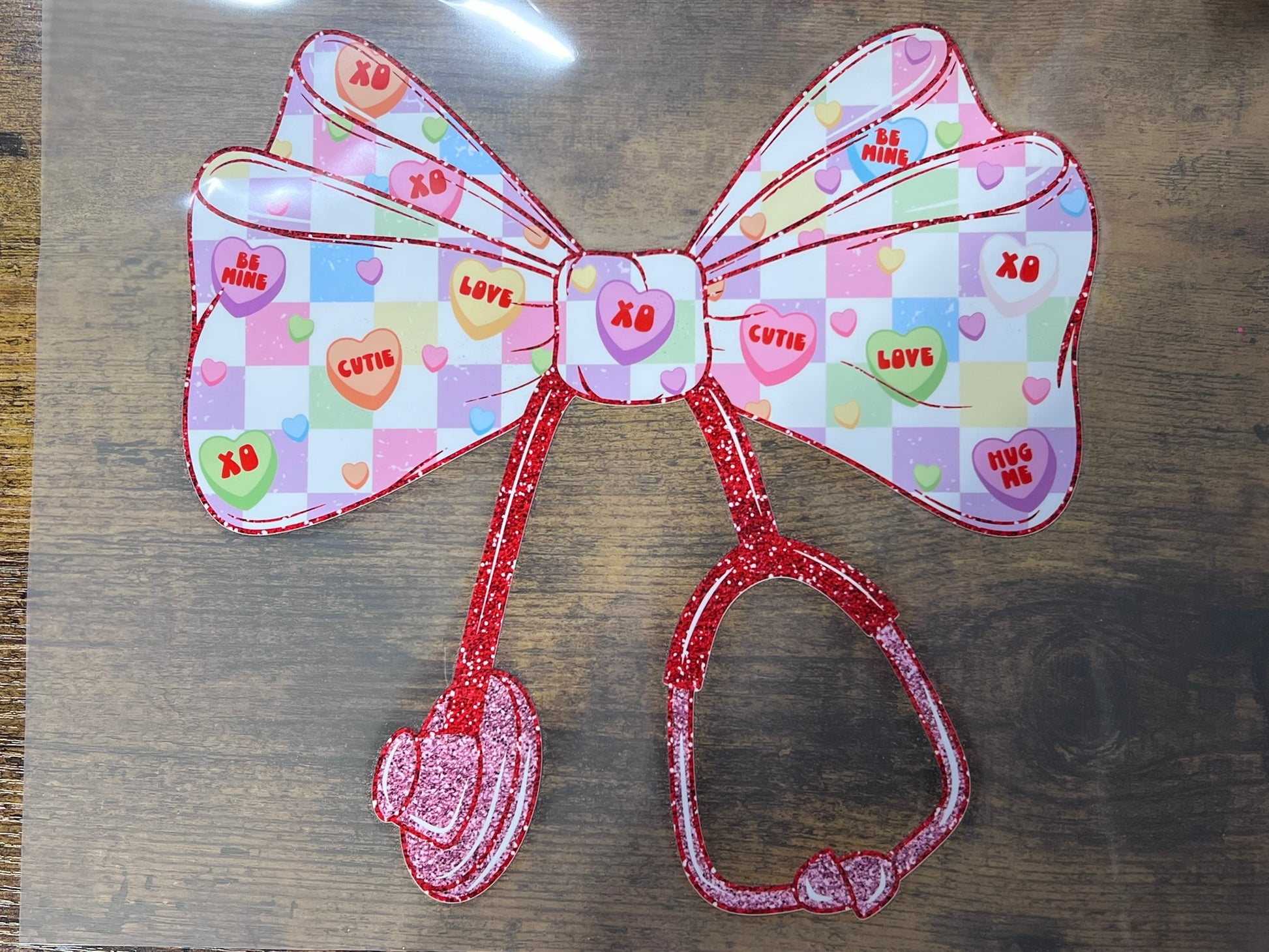 Ready-to-press DTF transfer featuring checkered bow with hearts and faux glitter stethoscope