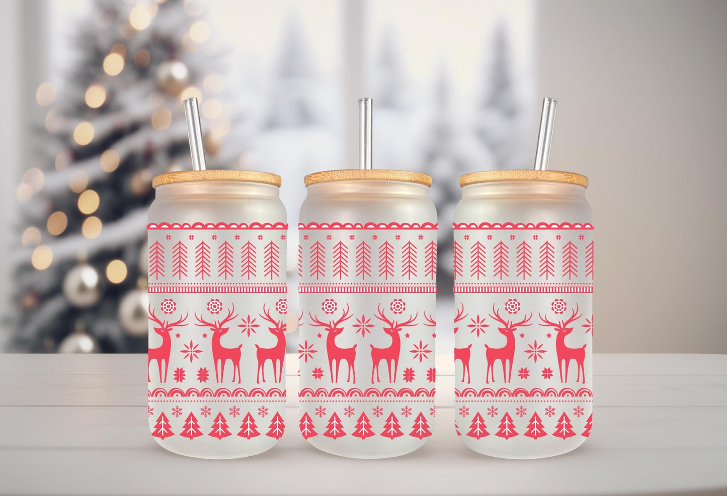 Three glass jars with red and white Christmas-themed designs, including reindeer and snowflakes, are arranged on a white surface.