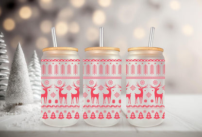 Three frosted glass mason jars with wooden lids, each adorned with a red and white Christmas-themed design featuring deer and snowflakes.